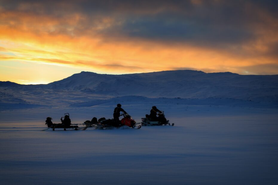 two men riding on snowmobile