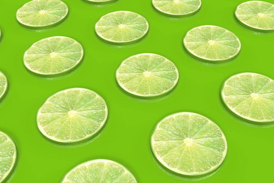 a group of lime slices sitting on top of a green surface